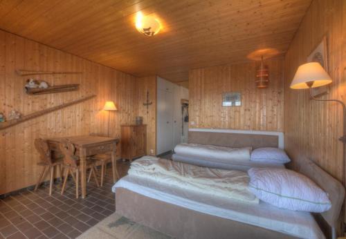 a bedroom with two beds and a table in it at Antares 403 au centre a Anzere in Anzère