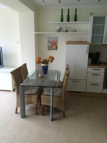 a dining room table with chairs and a kitchen at Fewo31, exklusive Apartments, 2 Minuten vom Strand und Alten Strom in Warnemünde