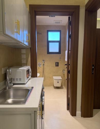 a kitchen with a sink and a toilet in a bathroom at Milano Hotel in Al-ʿUla