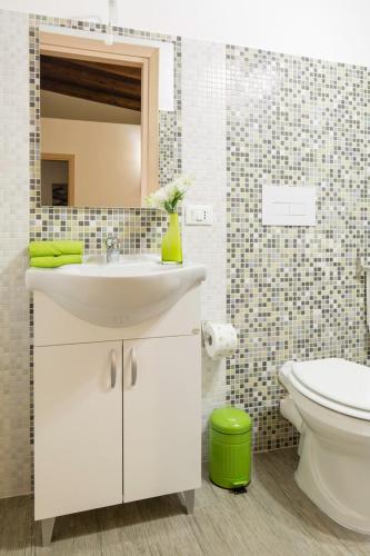 a bathroom with a sink and a toilet and a mirror at Arricàmpati Airport Rooms & Bringo Car Rental in Carini