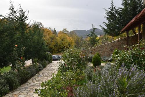 a garden with a car parked on a stone path at Trikalon Muses Art Suites in Synikia Mesi Trikalon