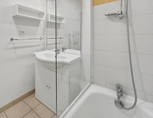 a white bathroom with a sink and a shower at T3 Piscine Classé 3, Park, Terrasse in Prayssac