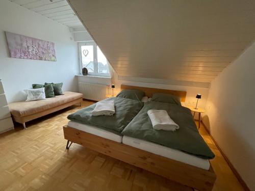 a bedroom with a large bed and a couch at Altrhein Hideaway ruhige Ferienwohnung nahe Frankfurt ideal für Natur & Radfahrer in Riedstadt