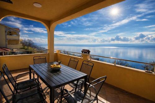 a table and chairs on a balcony with a view of the water at Villas Verde Dalmatia in Jesenice