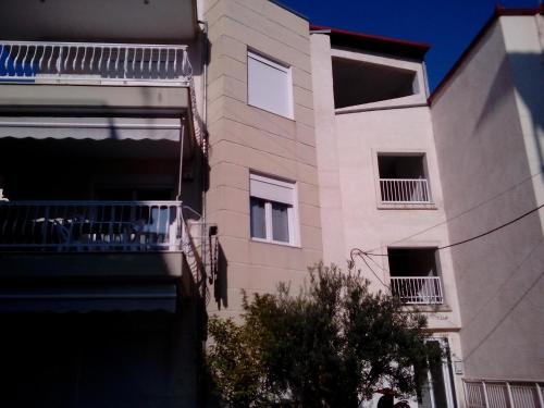 un edificio alto de color blanco con un balcón frente a él en Smell Sea, en Paralia Katerinis