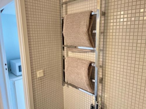 a bathroom with three towels on a wall at Tiny flat - in medieval Ystad in Ystad