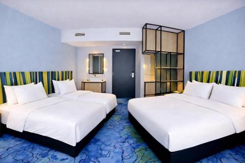 two beds in a hotel room with white sheets at IBIS STYLES MUENCHEN AIRPORT in Munich