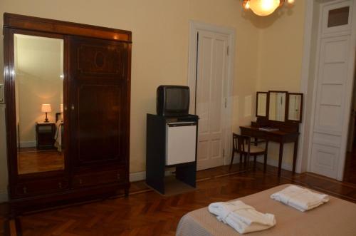 a room with a tv and a bed and a mirror at Argentino Hotel Casino & Resort in Piriápolis