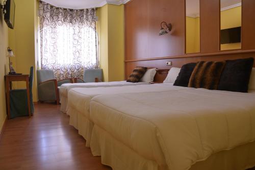 a hotel room with two beds and a window at Hotel Aro'S in Casas Ibáñez