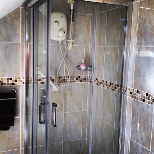 a shower with a glass door in a bathroom at Clai Ban in Kilronan