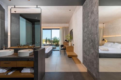 a bathroom with two sinks and a large mirror at Anasa Luxury Resort in Elaiokhórion