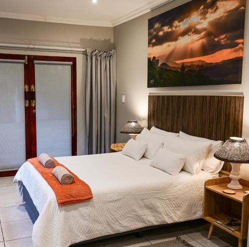 a bedroom with a large bed with two pillows on it at Son Heuwel B&B room in Nelspruit