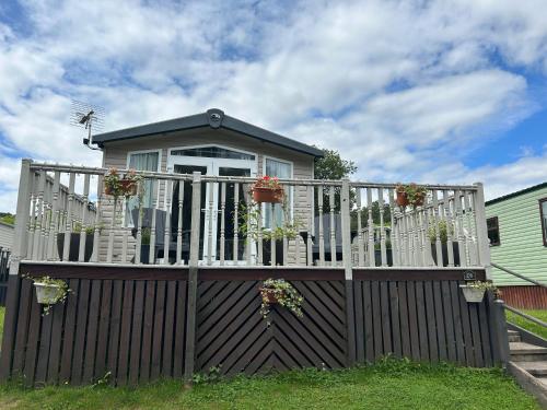a house with a wooden fence with potted plants on it at 26 Golf View in Jedburgh