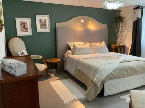 a bedroom with a bed and a table and a desk at Gîte EMOZIONE in Guebwiller