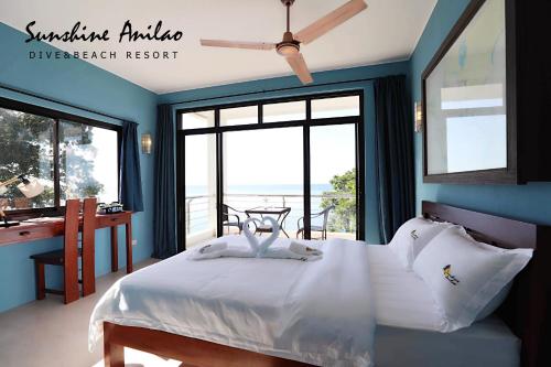 a bedroom with a bed with a view of the ocean at Sunshine Anilao Dive and Beach Resort in Batangas City