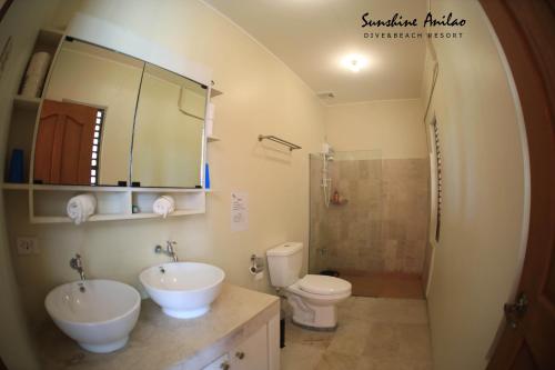 a bathroom with two sinks and a toilet at Sunshine Anilao Dive and Beach Resort in Batangas City