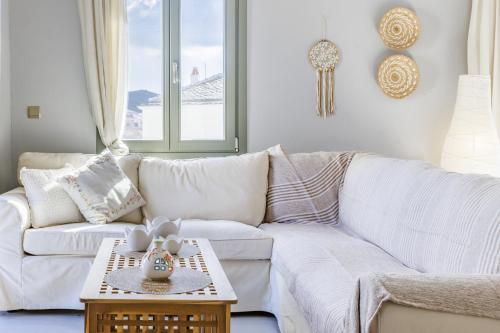 a living room with a white couch and a table at La Casa Del Limon - Sea Views & Walkable Location in Skopelos Town
