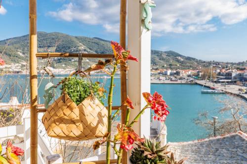 a balcony with flowers and a view of a harbor at La Casa Del Limon - Sea Views & Walkable Location in Skopelos Town