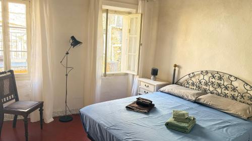 a bedroom with a bed with a lamp and a chair at Garibaldi by LigurianLife in Vallebona