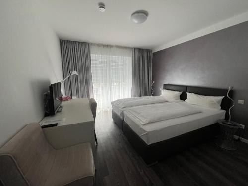 a bedroom with two beds and a desk and a couch at Victoria Living in Jockgrim