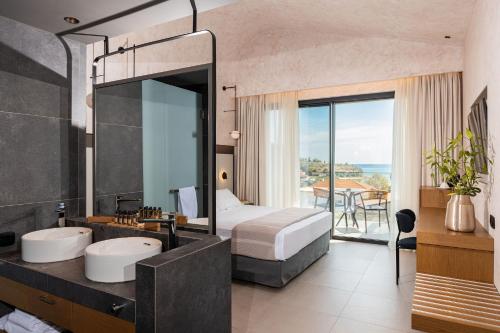 a bedroom with two sinks and a bed with a view at Anasa Luxury Resort in Elaiokhórion
