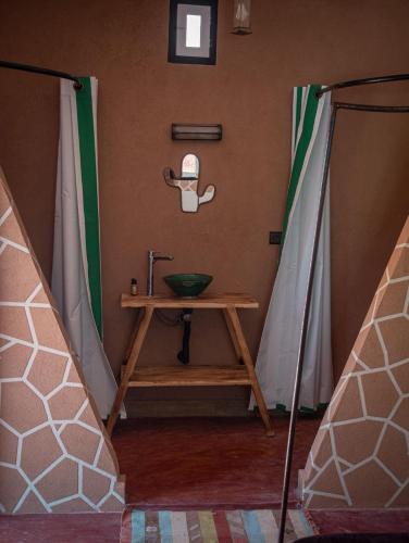 a bathroom with a sink in a room with curtains at Lodge bio berber nomad in Nkob
