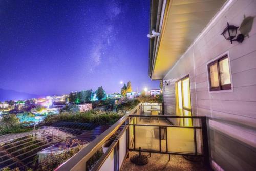 a balcony with a view of a city at night at Water Swing B&B in Ren'ai