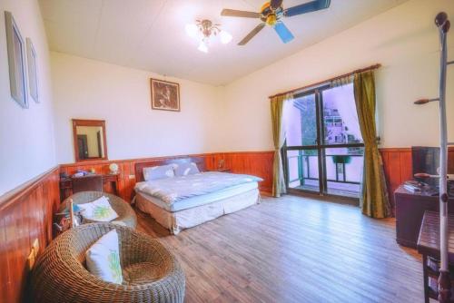 a bedroom with a bed and a ceiling fan at Water Swing B&B in Ren'ai