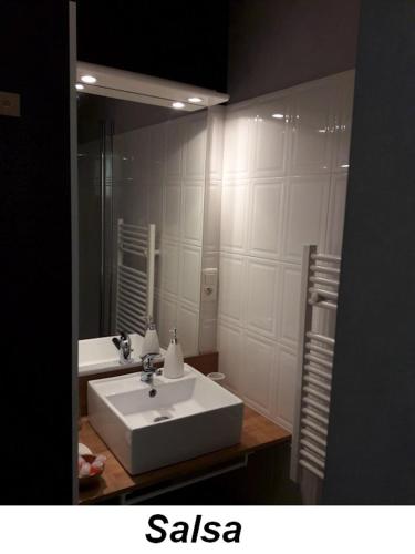 ein Badezimmer mit einem weißen Waschbecken und einem Spiegel in der Unterkunft LesFrugères in Boutiers-Saint-Trojan