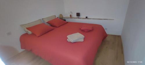 a bedroom with a red bed with red pillows at MAS Estrela Chambre Lo Roc in Bessèges