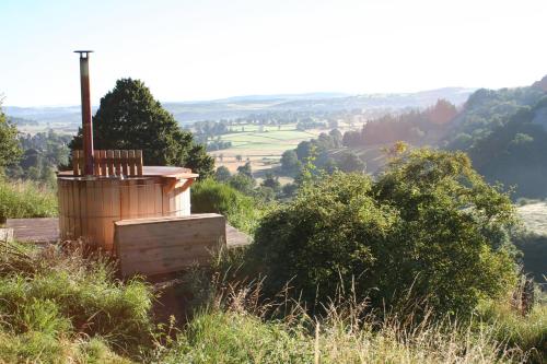 a wooden barrel sitting on top of a hill at Domaine de l'Ours / Camping Lodge in Saint-Urcize
