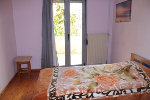 a bedroom with a bed with a flowered blanket on it at Komninos' Traditional House in Artemida