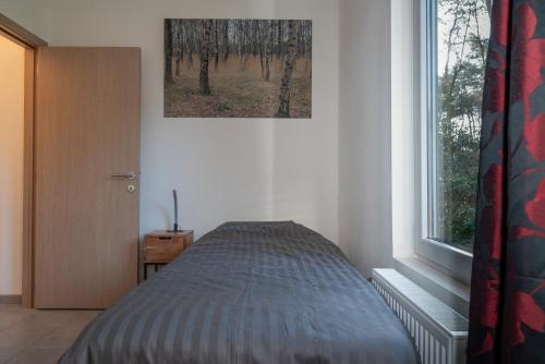 un letto in una stanza con una finestra di De Spetser a Merksplas