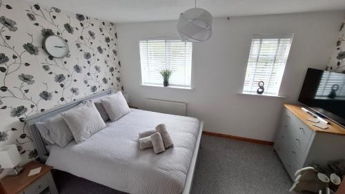 a bedroom with a bed with a teddy bear on it at Cosy Manorfield Holiday Home in Kent