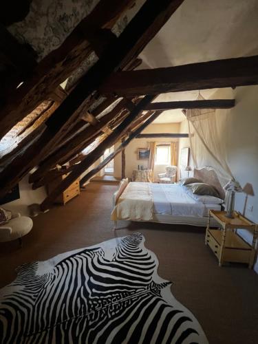 a bedroom with a zebra print bed in an attic at Mas De Garrigue - Chambres d'hôtes in Calvignac