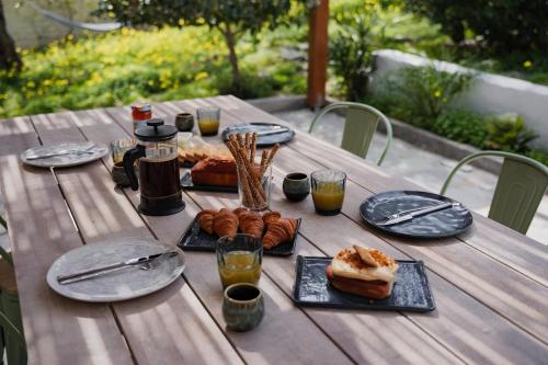 a wooden table with plates of food and drinks on it at Dia View Retreat in Elaía