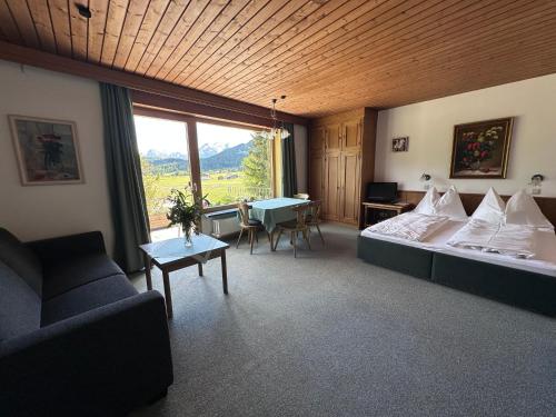 a room with a bed and a couch and a table at Chalet Cristall Superior Appartement 7 in Leutasch