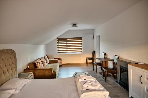 a bedroom with a bed and a couch and a table at Viv House in Vălenii de Munte