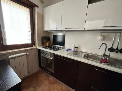 a kitchen with white cabinets and a sink and a stove at Casa Montessori in Avezzano
