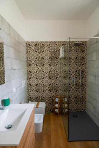 a bathroom with a toilet and a sink and a shower at The Garden in Pulsano