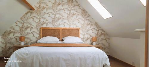 a bedroom with a large bed with a wall at Au sable de l'estran in Cucq