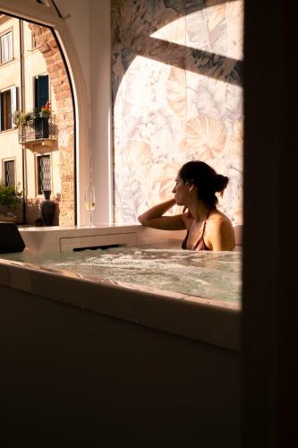 a woman sitting in a bath tub in a bath tub at Corte Bonfiglio Colombari in Illasi