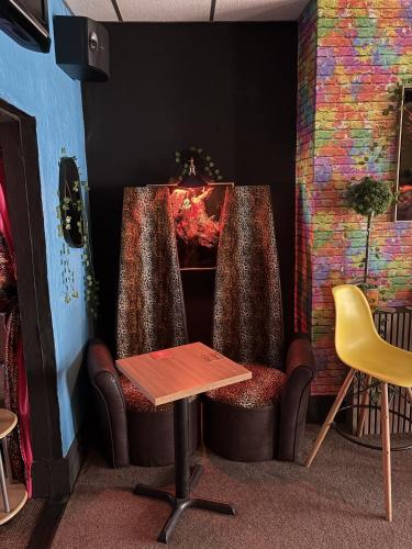 a room with a chair and a table and a fireplace at Evanescent in Blackpool