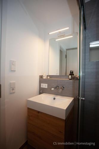 a bathroom with a white sink and a mirror at Seensucht in Bodman-Ludwigshafen