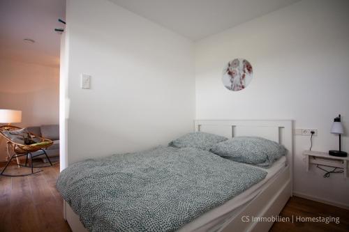 a bed in a white room with at Seensucht in Bodman-Ludwigshafen