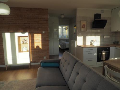 a living room with a couch and a kitchen at Apartament Secundus in Ełk
