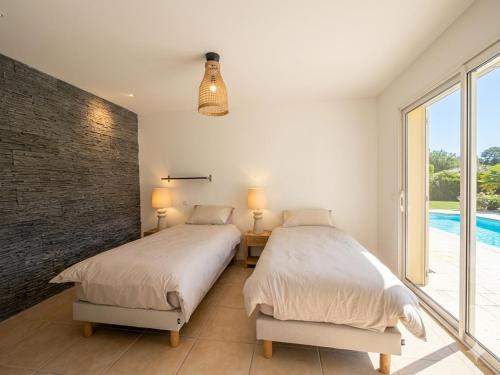 two beds in a bedroom with a brick wall at Domaine de Quintessence in Saint-Justin