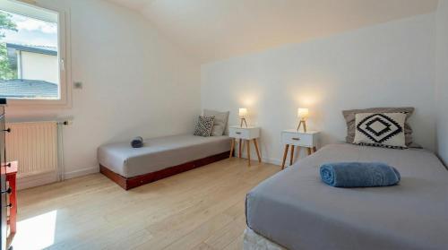 a small bedroom with two beds and a window at Villa Galante in Meylan