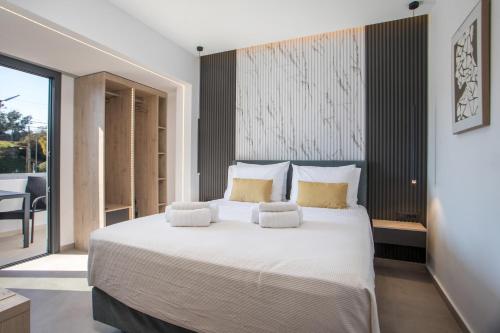 a bedroom with a large white bed with yellow pillows at Kallithea living in Koskinou