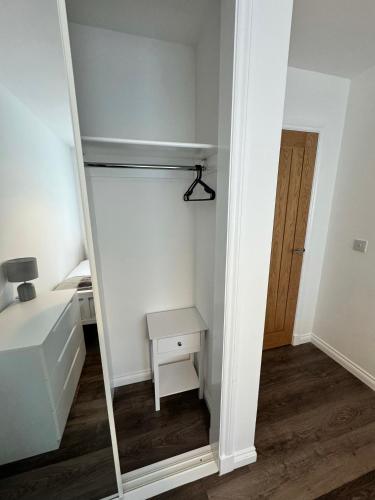 a small bedroom with a mirror and a desk at Inchmoan Apartment in Bonhill